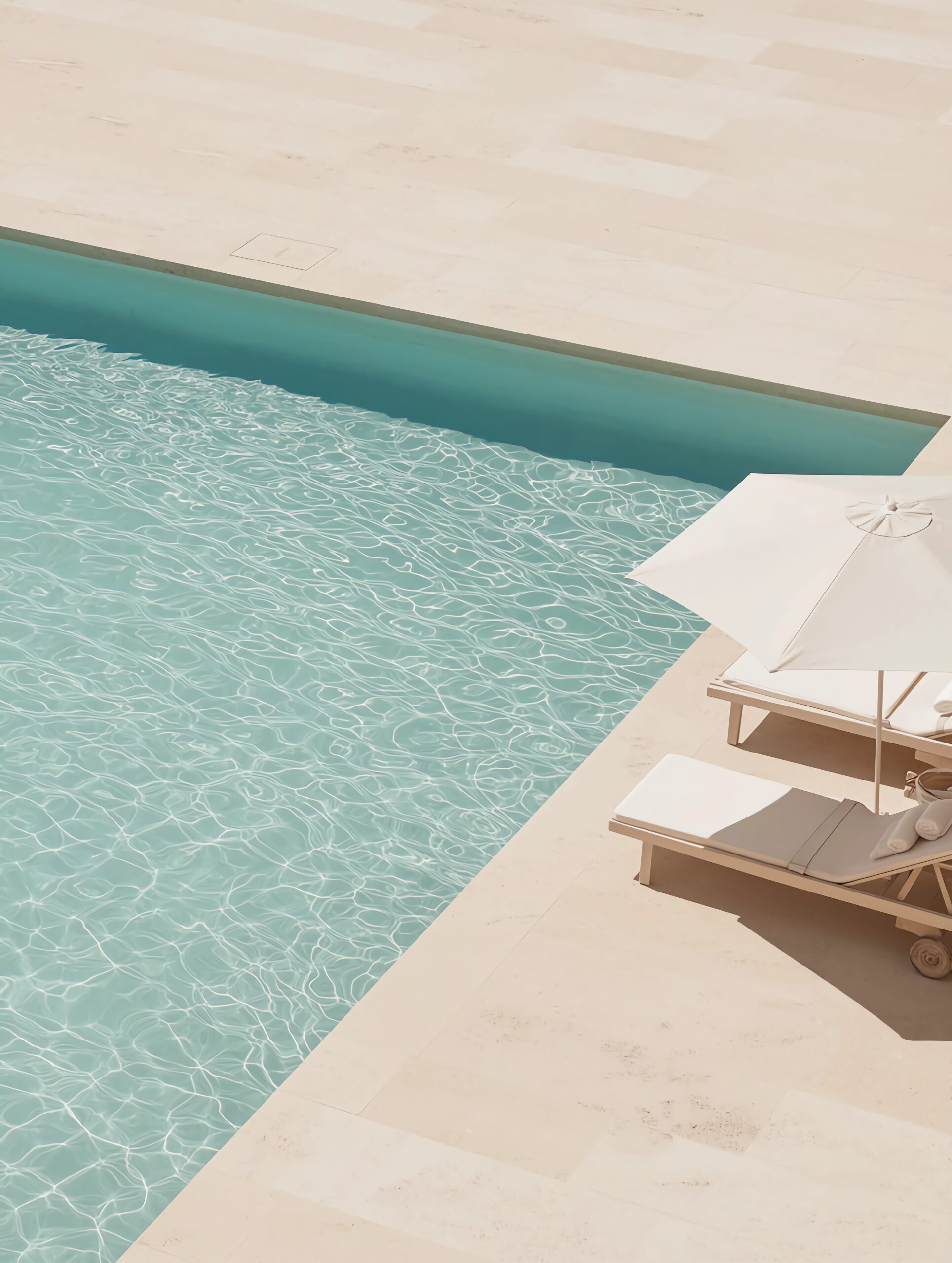 aerial view of sun loungers under umbrella next to a pool