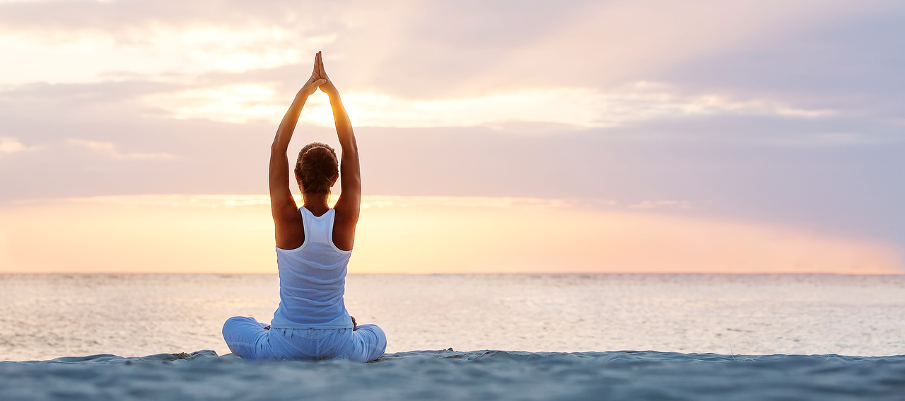 Woman practicing yoga outdoors at sunrise