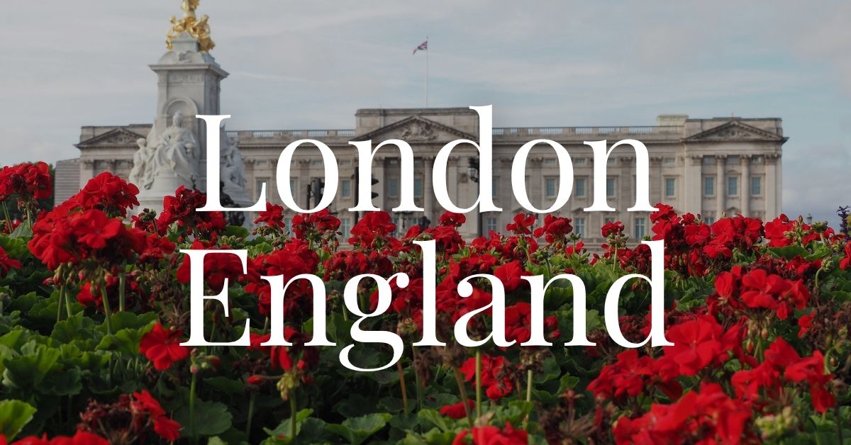 Buckingham Palace in London, England behind a row of red flowers