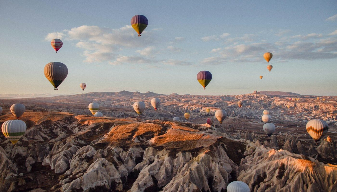 hot air balloons flying over the mountains during daytime