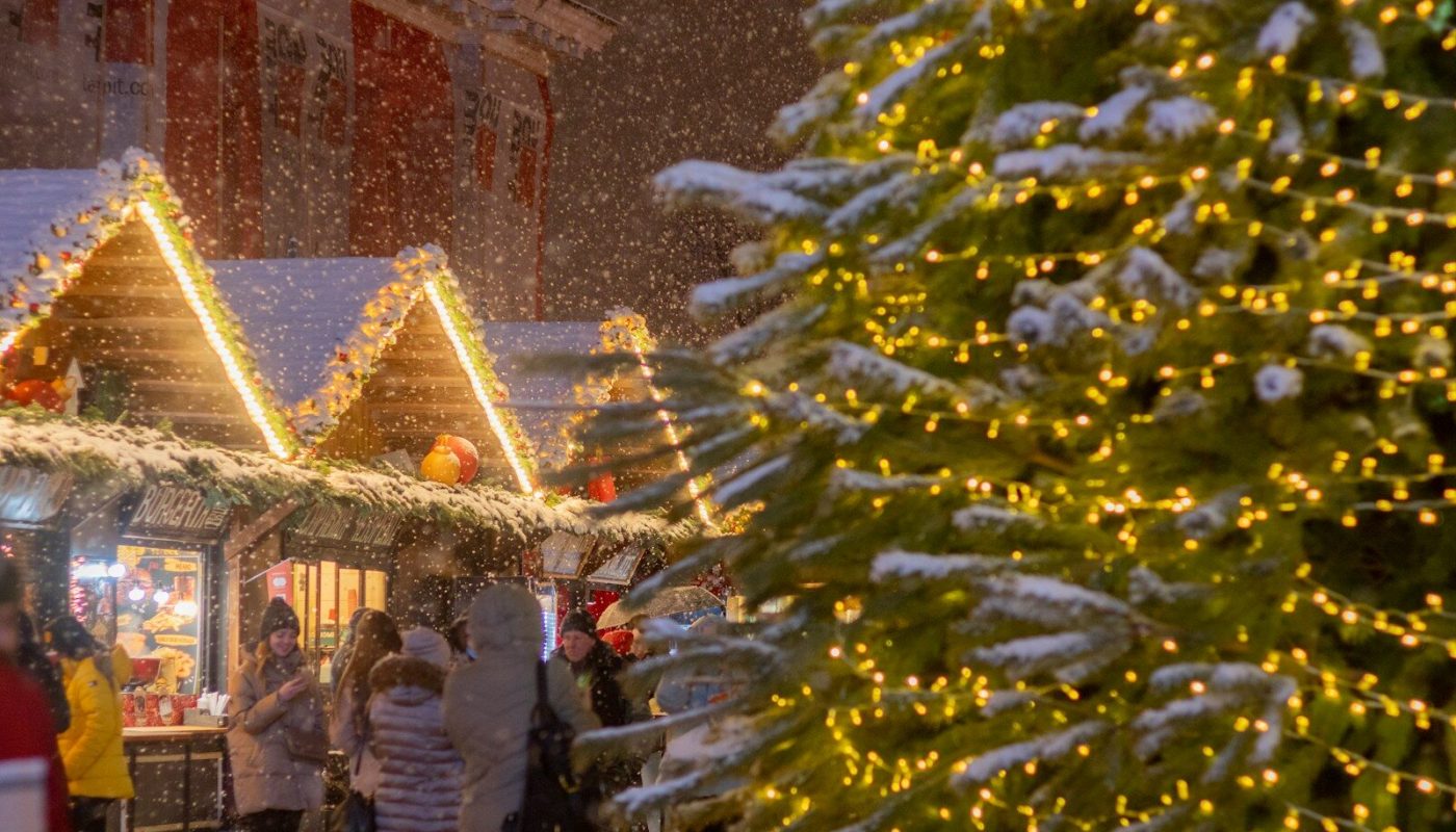 a group of people standing around a christmas tree